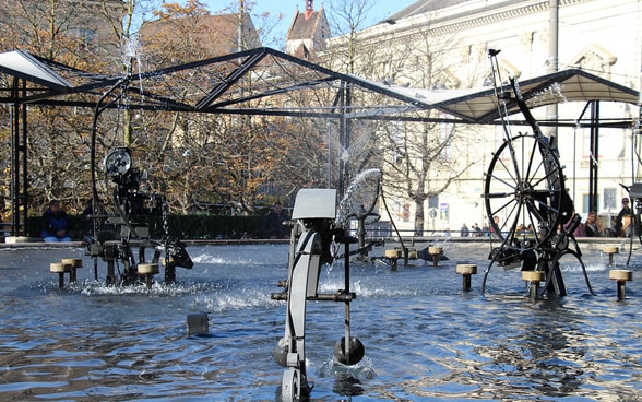 Maschinelle, bewegte und wassersprühende Skulpturen im Wasser am Theaterplatz in Basel.