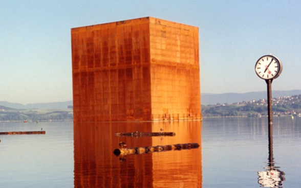 Un monolito de metal oxidado en la superficie del lago de Morato.