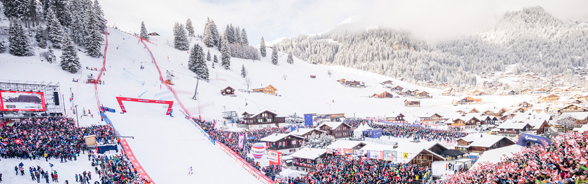 A skier at the finish of the Adelboden giant slalom is greeted by hundreds of spectators waving Swiss flags.