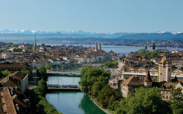 A cidade de Zurique à frente do Lago de Zurique e dos Alpes.