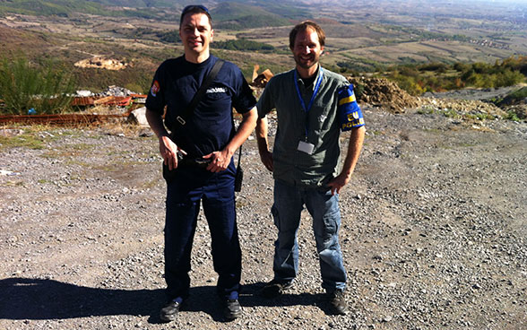 Deux hommes sur une place recouverte de gravier au Kosovo.