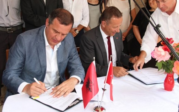 Swiss Amassador Christoph Graf and Minister of Health Ilir Beqja signing the new agreement in Peshkopi, Albania 