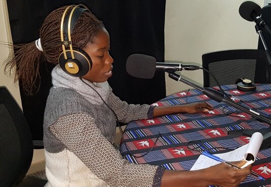 Jeune femme en studio, microphone en face