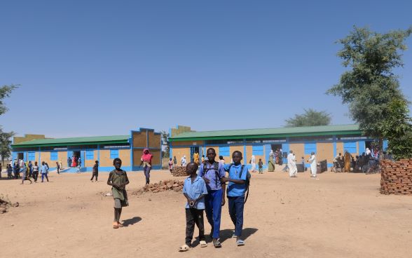 Children in the school playground. Behind them, the new classrooms at the school in the Koundjourou sub-prefecture. 