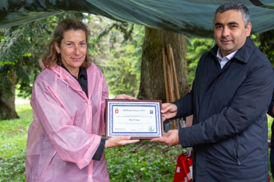 the local official hands over a certificate of appreciation