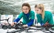 Two young women checking cables.