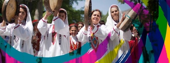 Women in traditional dress welcome guests.