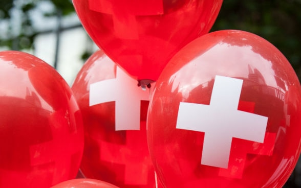 Red balloons with the white Swiss cross