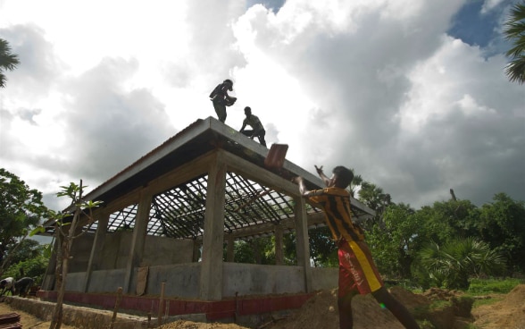 Singalesi lavorano nel cantiere di una nuova casa.