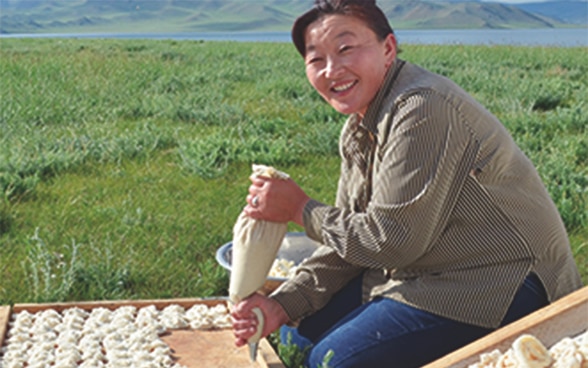 Eine Frau bei der Zubereitung eines traditionellen mongolischen Snacks 