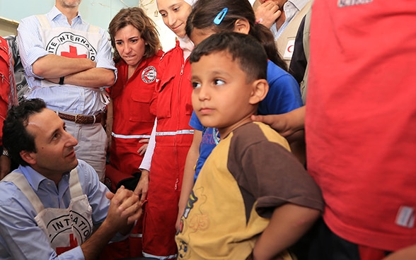 Robert Mardini spricht auf einem Feldbesuch mit Kindern.