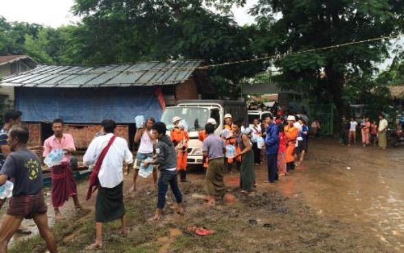 Emergency workers and civilians pass bottles of water along a human chain.