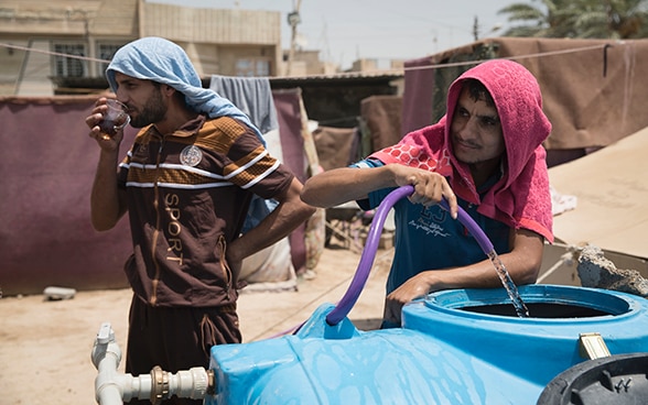 A man fills a jerrycan with water.