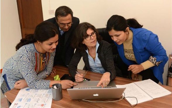Schweizer Expertin Jennifer Duyne Barenstein diskutiert mit zwei Kolleginnen und einem Kollegen vor einem Computer
