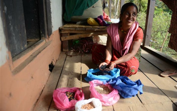 Une villageoise montre les différents types de semences qu’elle a reçus