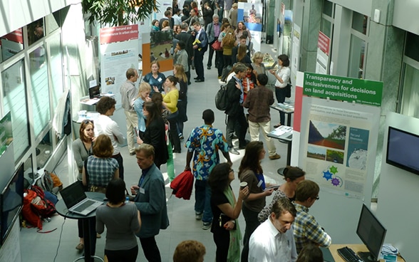 Visiteurs de la Foire de la recherche se promenant et échangeant dans les divers stands.