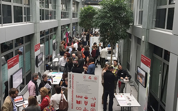 Besucherinnen und Besucher im Gespräch an den Ständen der «Research Fair».