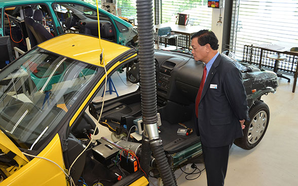 A member of a foreign delegation takes a look at a car that apprentices practice on at the Swiss Technical College in Winterthur. 