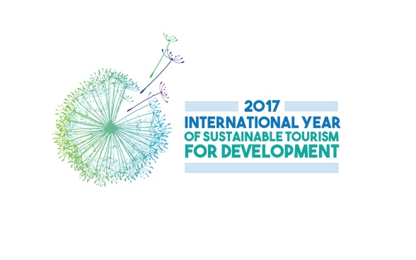 Logo des Internationalen Jahrs des nachhaltigen Tourismus: Pusteblume, von der sich drei Flugschirme gelöst haben.