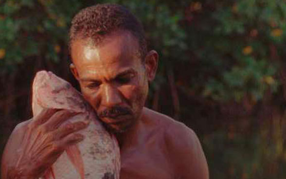 Ein brasilianischer Fischer nimmt den gefangenen Fisch eng an seine Brust.