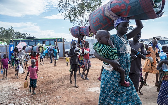 Frauen und Kinder kommen in einem Flüchtlingslager an.