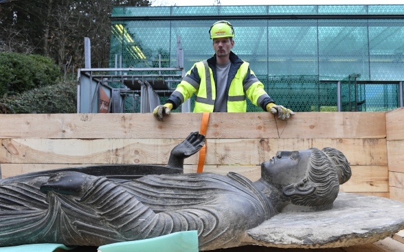La statua di Buddha dentro il suo contenitore davanti al Museo Rietberg.