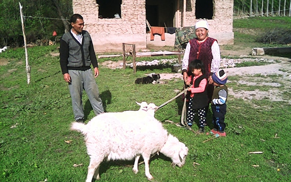 Nurdinov Jeenbek’s family with the goat that he received through the project.