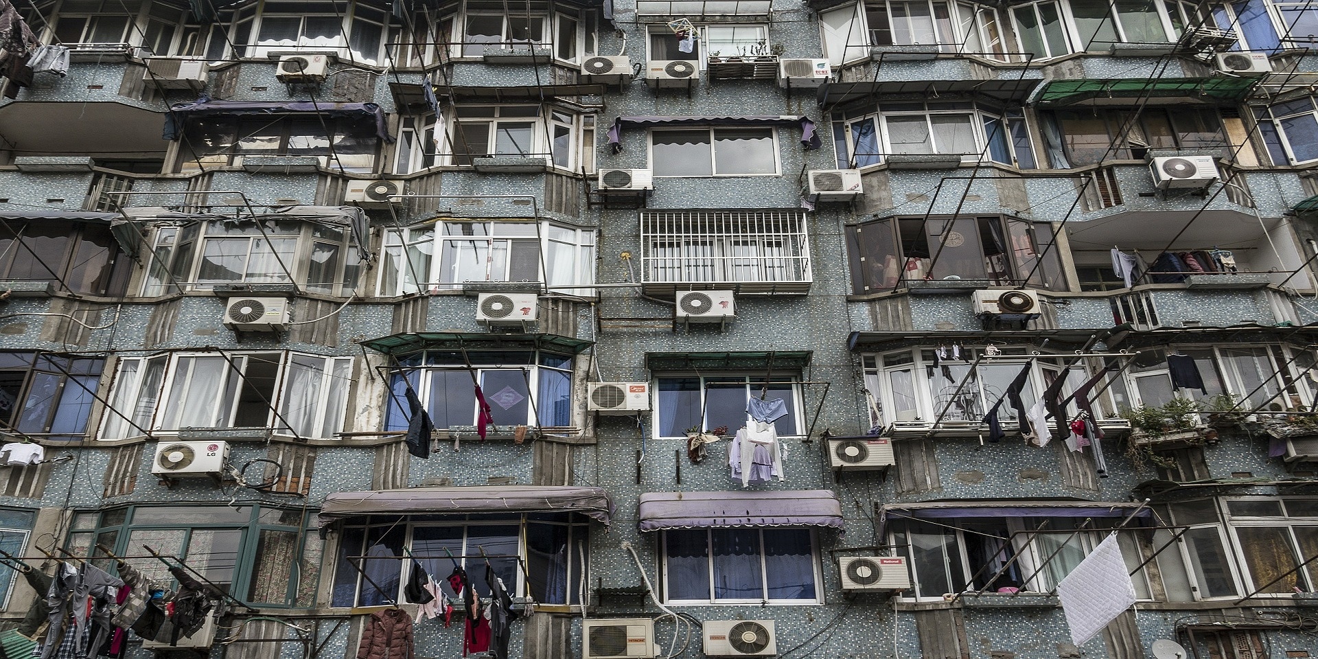 Hausfassade mit vielen alten Klimaanlagen.