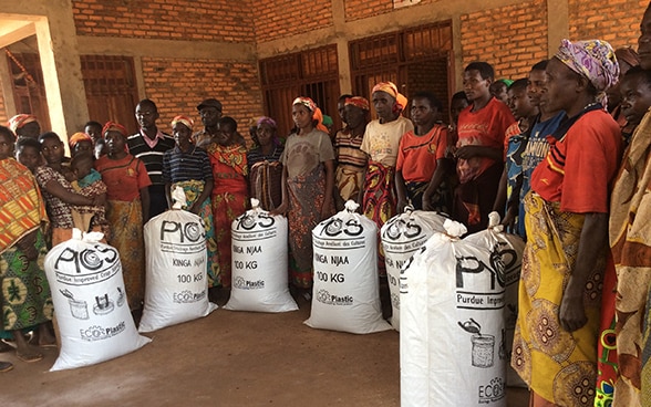 A group of African women posing with filled PICS bags.