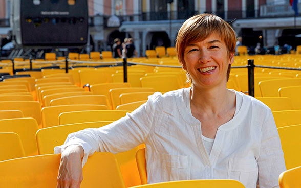 La responsabile di Open Doors Sophie Bourdon seduta sulle sedie gialle del Locarno Film Festival posizionate in Piazza Grande a Locarno.