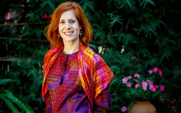 Dans sa tenue chamarrée, Nathalie Chuard sourit au photographe.