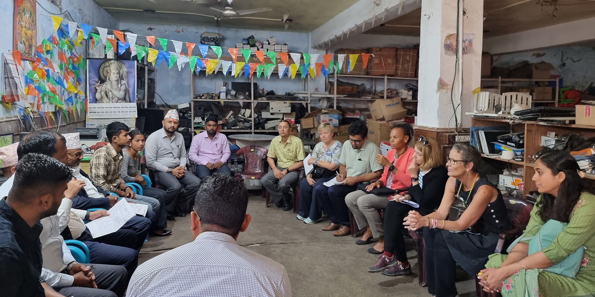 La Direttrice della DSC Patricia Danzi durante una visita a un centro di formazione informatica in Nepal. I partecipanti alla discussione sono seduti in cerchio. Tra loro ci sono due studenti.