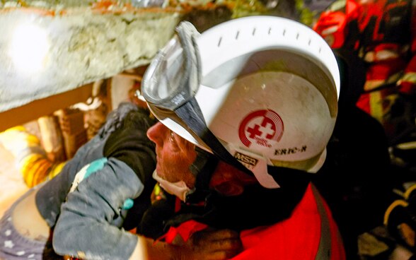 A member of the rescue chain holds a girl in his arms whom he has just rescued.