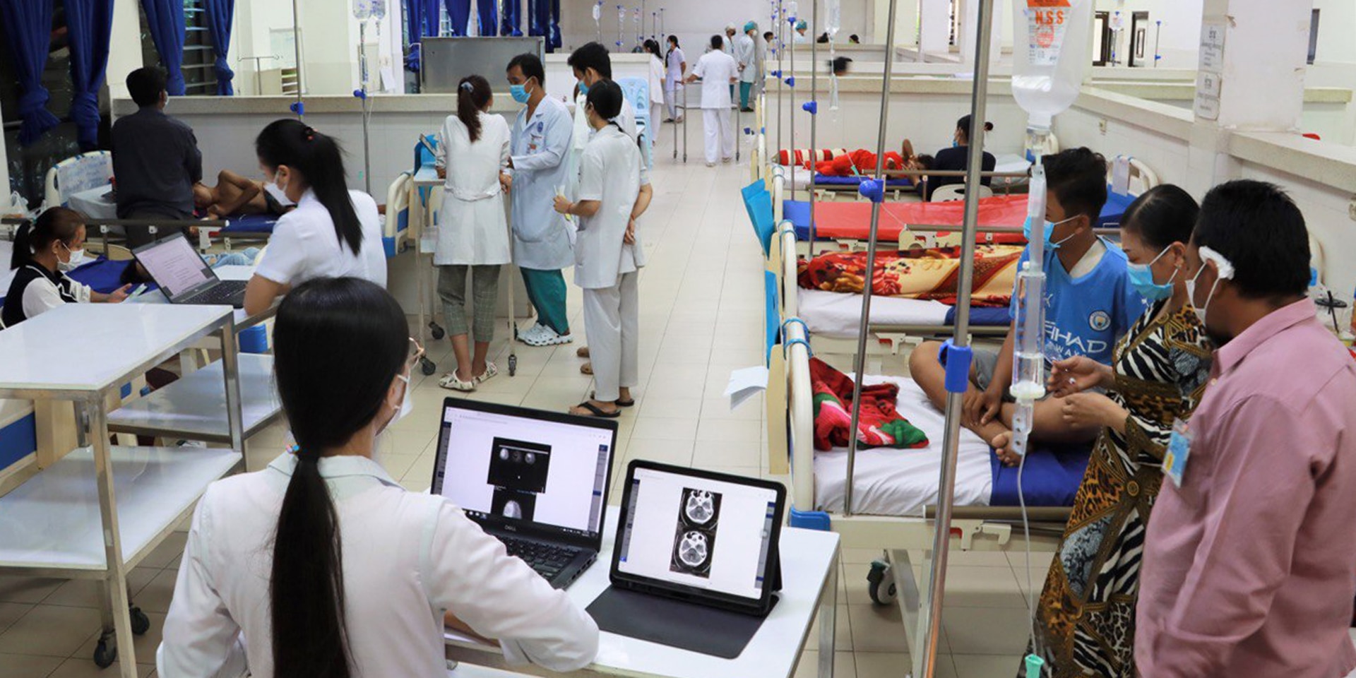 Interno di una grande stanza in un ospedale pediatrico Kantha Bopha con pazienti e personale di cura. 