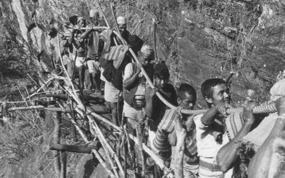 Un gruppo di nepalesi porta al cantiere cavi d’acciaio per il ponte sospeso.