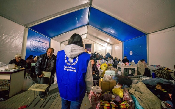 An employee of the World Food Programme stands in a tent