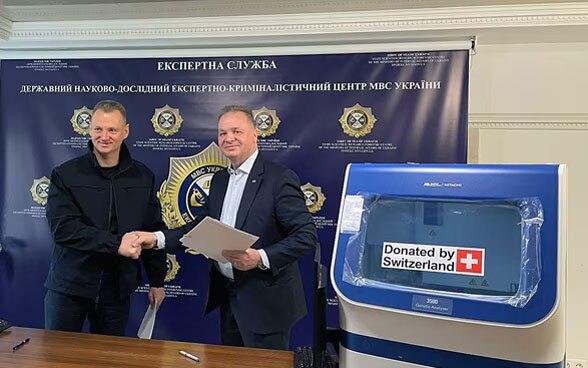 Claude Wild, antiguo embajador en Ucrania, entrega material para hacer análisis de ADN al Centro Estatal de Investigación Científica Forense en Kiev.