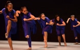 Five Indonesian dancers performing an expressive choreographed piece on stage.