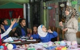In un’aula del campo profughi di Khan Dunnoun in Siria alcune ragazze ascoltano attentamente la loro insegnante.