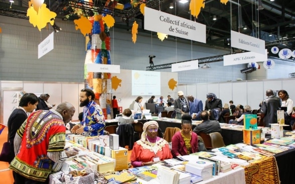 Ein Stand am «Salon africain», an dem Verlage afrikanische Literatur anbieten und sich eine interessierte Leserschaft Werke ansieht.