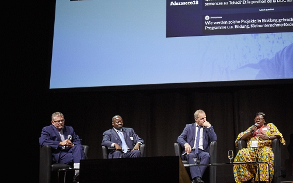 Mansour N’Diaye, Dominique Guenat, Pierre-André Page, Mariane Nguerassem e la moderatrice Melanie Pfändler siedono sul palco. Sullo sfondo si vede il PowerPoint sul quale sono visualizzate le domande del pubblico.