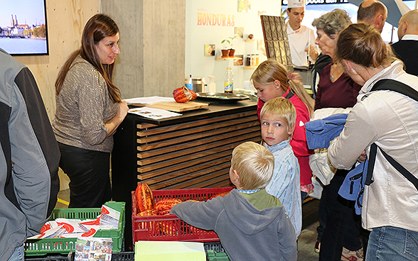 Des enfants et des adultes devant le stand Honduras de l'exposition spéciale de la DDC à l'OLMA 2015.