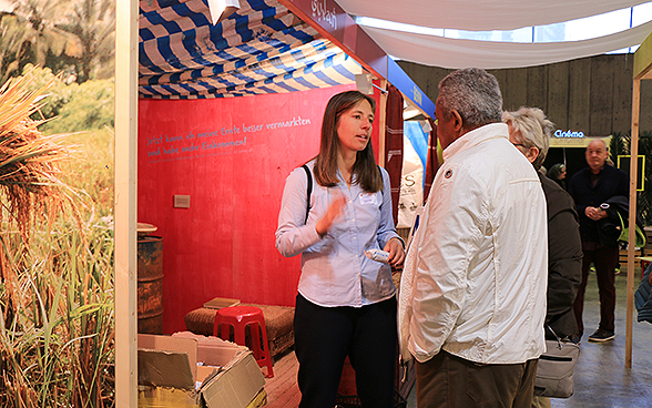 Eine DEZA-Mitarbeitende spricht an der OLMA 2015 mit einem Besucher.