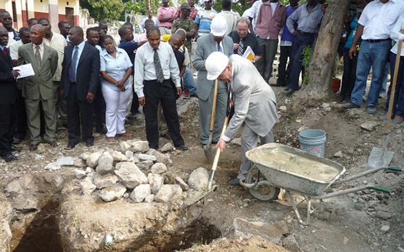 Ambassador Urs Berner, shovel in hand, is surrounded by a number of Haitian officials. © SDC