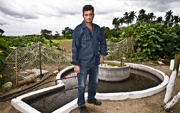 Fernando, paysan, devant un réservoir (fermenteur) servant à la production de biogaz à partir de lisier (Calimete, prov. de Matanzas)