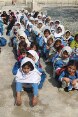Pakistanische Schülerinnen sitzen in Reihen hintereinander.