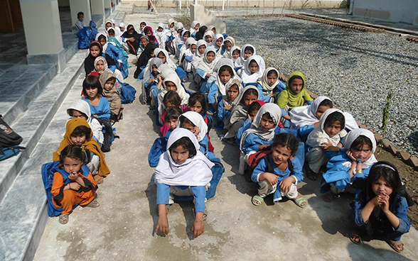 Pakistanische Schülerinnen sitzen in Reihen hintereinander.