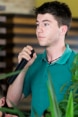 A young man holding a microphone in his hand, listening intently to the discussion.