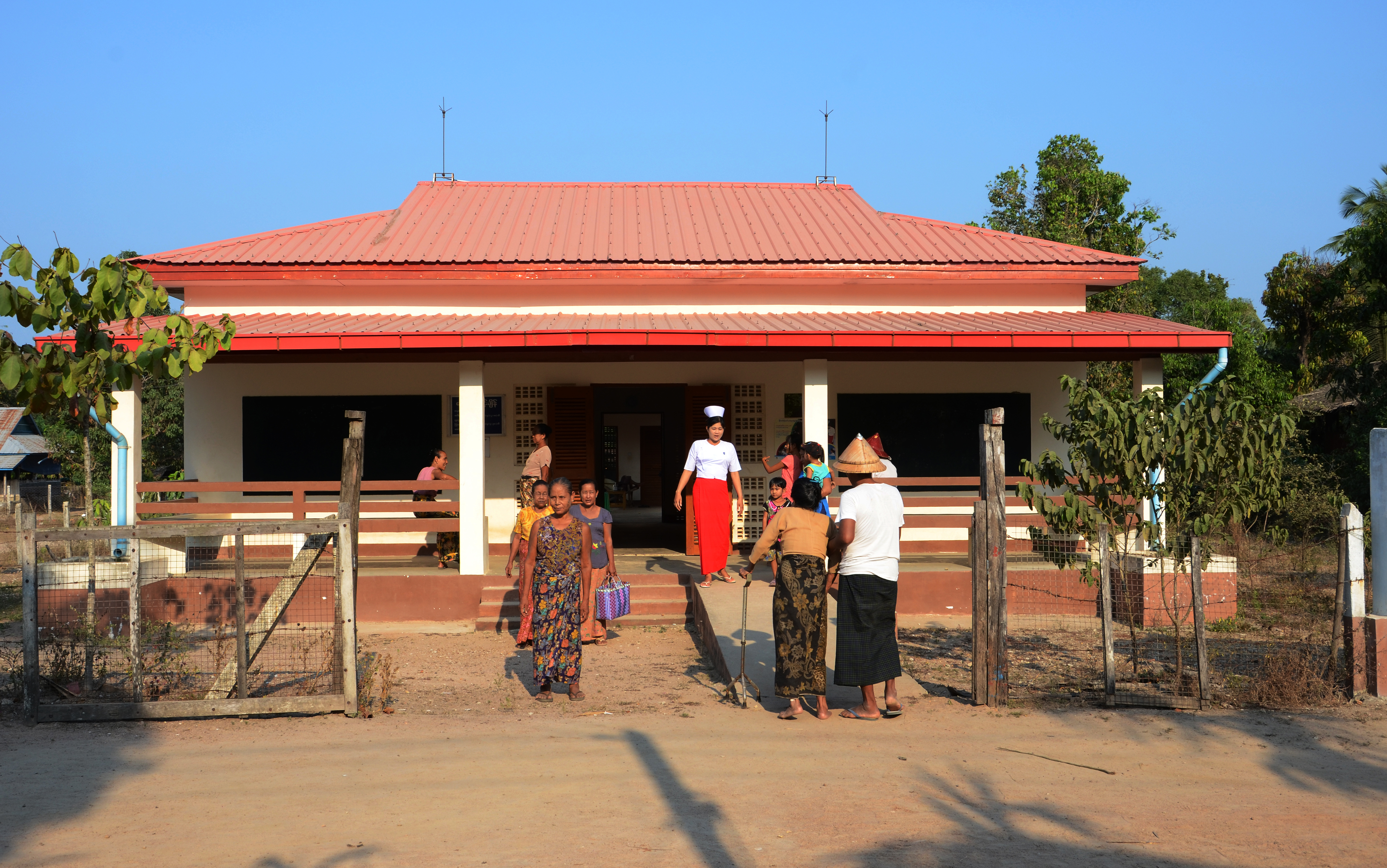 Eine Krankenschwester empfängt Patientinnen und Patienten am Eingang eines Gesundheitszentrums. 