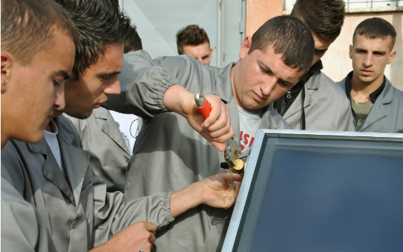 A student screwing a solar panel together.